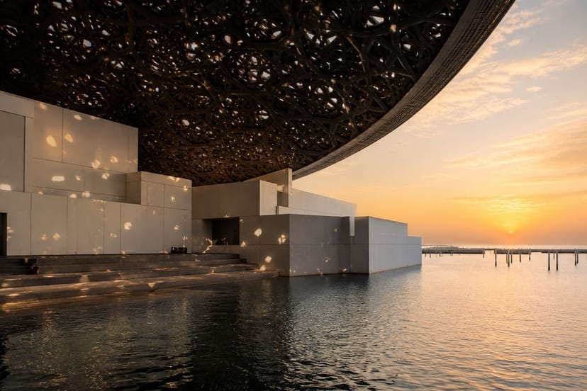 Louvre Abu Dhabi dome over still water at dusk